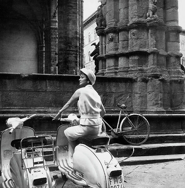 The actress Olivia de Havilland in Lambretta near to the Loggia dei Lanzi in Florence