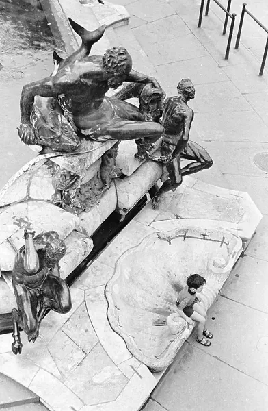 Child sitting on the fountain of Neptune in Piazza della Signoria in Florence