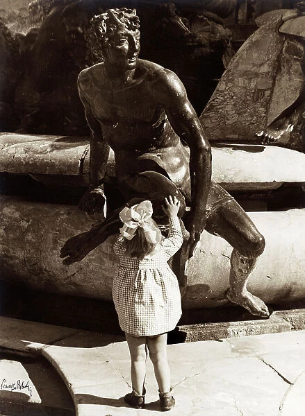 Girl near a bronze statue of the Neptune fountain in Piazza della Signoria, Florence