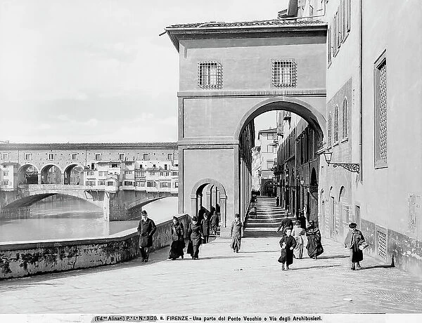 View with people of Lungarno degli Archibusieri and part of the Vasari Corridor. Ponte Vecchio is in the background