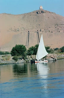Images Dated 25th October 2011: assuan a felucca passing along the coasts where there are some rich tombs of pharaonic lords of