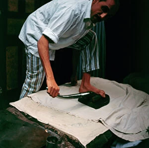 Images Dated 21st December 2011: Cairo. Launderer in the district of Kan-Kalili (use your foot to move the iron)