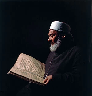 Images Dated 19th December 2011: Cairo. An old man reads a holy book of Islamic holy