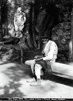 Images Dated 6th May 2011: An elderly man sitting on a bench near the statue of Bes of the Magical Alchemical Gate in