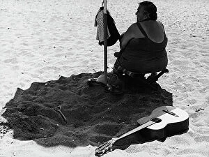 Images Dated 29th March 2011: Elderly woman under beach umbrella