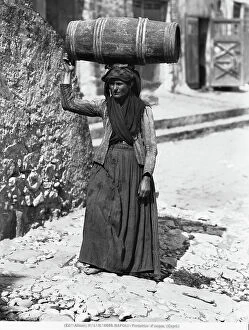 Images Dated 3rd February 2010: Elderly woman carrying a barrel of water on her head, standing on a staircase in Capri