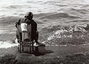 Images Dated 9th October 2008: Elderly woman seated on the shore-line