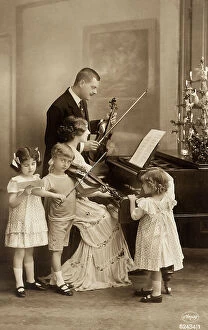 Images Dated 7th August 2009: Family portrait while playing music with violin and piano where is laying the Christmas tree