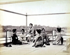 Images Dated 28th November 2011: Geishas wearing kimonos on a terrace while serving tea