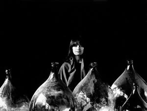 Images Dated 9th May 2011: 'Glass eyes'. Young woman next to large bottles