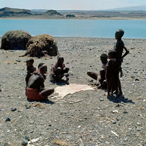 Images Dated 6th July 2009: A goat skin stretched in the sun surrounded by women and children of Turkana ethnicity