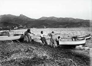 Images Dated 4th August 2009: Group committed to putting ashore a boat on the Portoferraio beach, Elba Island