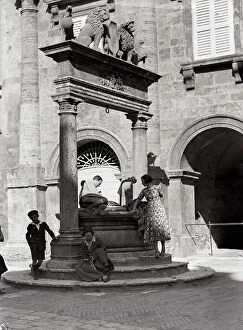 Images Dated 20th March 2009: Group beside a renaissance well in the piazza Grande in Montepulciano