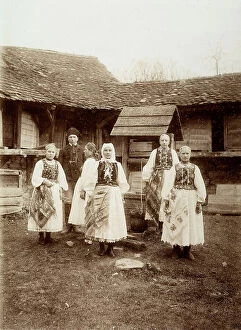 Images Dated 28th March 2011: A group of women and a man, in typical Rumanian clothes, photographed next to some houses in