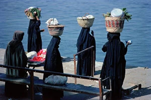 Images Dated 12th October 2011: Luxor in Upper Egypt, women carrying baskets of vegetables to the market waiting to catch the ferry