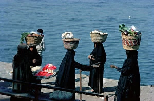 Images Dated 12th October 2011: Luxor in Upper Egypt, women carrying baskets of vegetables to the market waiting to catch the ferry