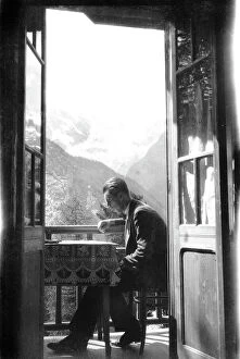 Images Dated 29th November 2007: Man intent to read while sitting on the terrace of a house in the mountains