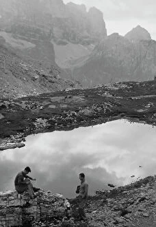 Images Dated 24th November 2011: Two men sitting near a mountain lake, Cortina d'Ampezzo
