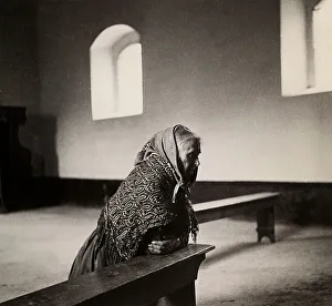 Vieille femme à genoux devant lautel dans une église