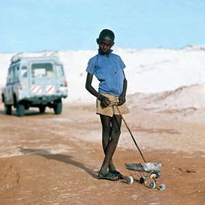 Images Dated 17th November 2009: Mogadishu. Along a track of sand, a boy and a rudimentary toy