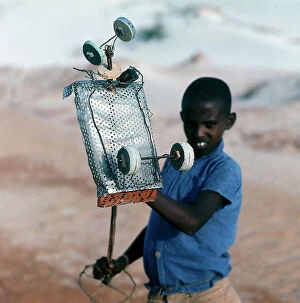 Images Dated 17th November 2009: Mogadishu. Along a track of sand a little boy and a rudimentary toy