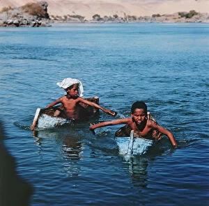 Images Dated 11th October 2011: Nubian kids on rudimentary boats with which they play and cross the river