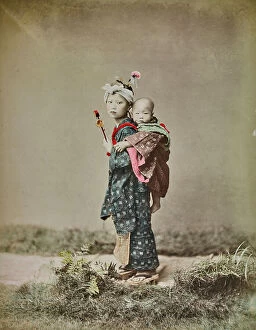 Japan: Portrait of a japanese girl with traditional clothes holding a newborn baby on her shoulders