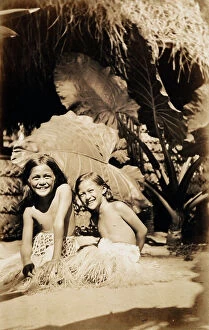Images Dated 25th November 2011: Portrait of two Tahitian children sitting in the shade of a tropical plant