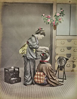 Japan: Portrait of a young japanese woman while holding hair at a woman in front of the mirror