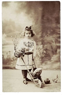 Images Dated 19th September 2007: Portrait of a young little girl carrying a small basket, a hand-cart and an Easter egg