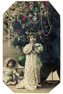 Images Dated 19th September 2007: Portrait of a young little girl praying under the Christmas tree, Christmas greeting post-card