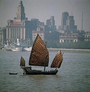 Images Dated 27th October 2009: Shanghai. A sailing junk passes in front of buildings in the commercial center of Shanghai