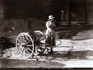 Images Dated 22nd June 2009: On a street in Rome, a streetsweeper rests next to her cart
