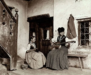 Images Dated 3rd May 2010: Woman playing the guitar next to a young girl crocheting, Casa Apollonio Cortina
