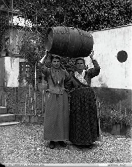 Images Dated 14th September 2011: Two women bearing a wine cask on their heads in San Remo