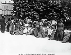 Images Dated 10th April 2012: Women in traditional costume next to wicker chests at a market in Lucerne