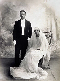 Images Dated 23rd November 2009: Young bride and groom on their wedding day. The woman is seated, enveloped in the long wedding veil