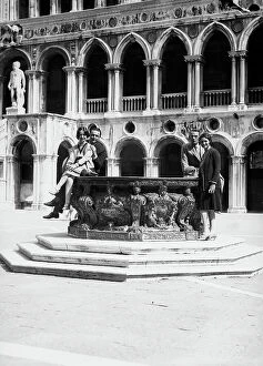 Images Dated 23rd June 2009: Young couples posing on the edge of a well in the courtyard of the Palazzo Ducale, Venice