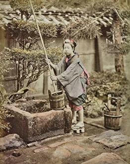 Japan: A young Japanese woman collects water from a well